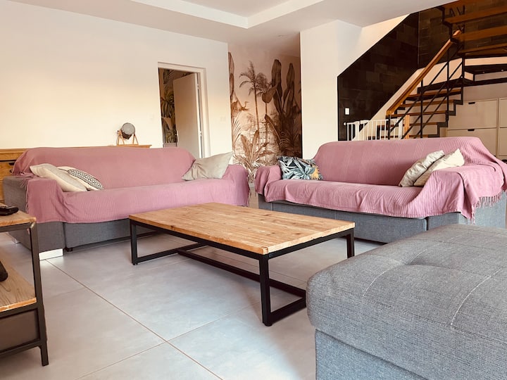 Salon spacieux avec canapés et escalier design