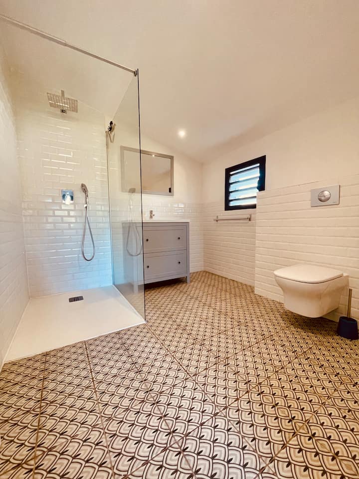 Salle de bain avec douche à l'italienne et carrelage motif